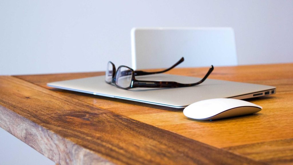 Minimal desk with a laptop and glasses